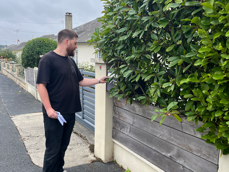 un agent municipal distribue un courrier aux habitants 